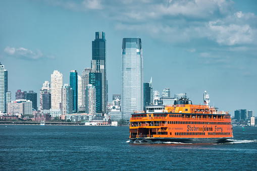 Jersey City Skyline and Staten Island Ferry, New Jersey, USA as seen from New York Harbor.