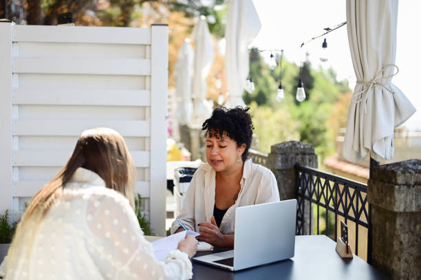 istock Female multiracial manager taking notes during interview with candidate outdoors. 1756645046