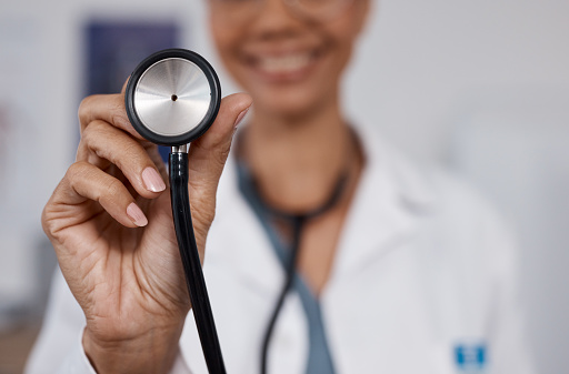Cardiology doctor, stethoscope closeup and black woman in healthcare, heart wellness and consultation pov. Friendly medical professional or cardiologist in clinic or hospital exam with happy service