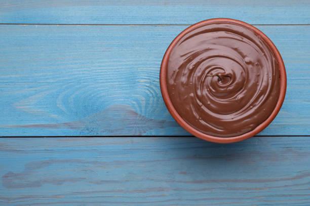 istock Tasty chocolate paste on light blue wooden table, top view. Space for text 1756681382