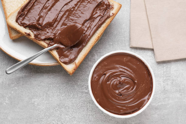 istock Tasty breakfast. Toast with chocolate paste served on grey textured table, flat lay 1756681906