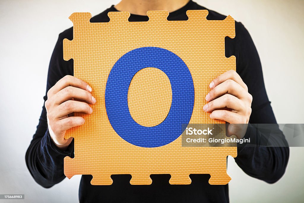 Alfabeto quebra-cabeça, segurando a letra O - Foto de stock de Azul royalty-free