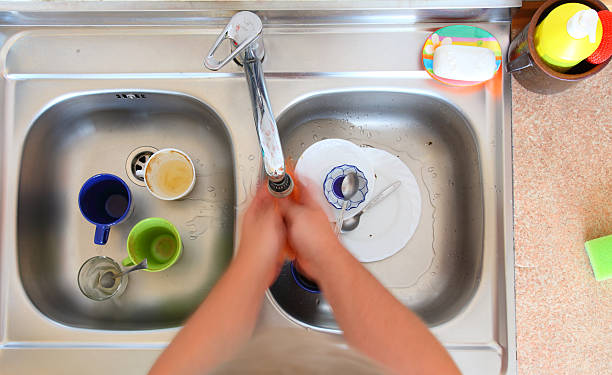 lavavajillas bowl persona de limpiar el lavamanos de la cocina - rag cleaning chrome transparent fotografías e imágenes de stock