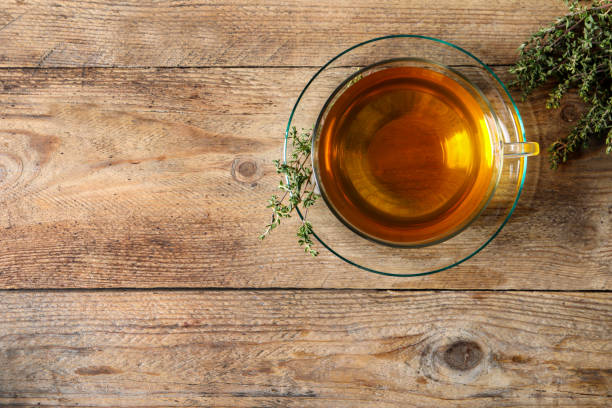 istock Aromatic herbal tea with thyme on wooden table, flat lay. Space for text 1756699556
