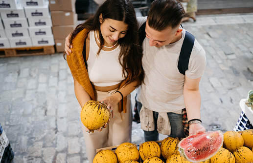 Couple is looking for the best melon on the farmer's market
