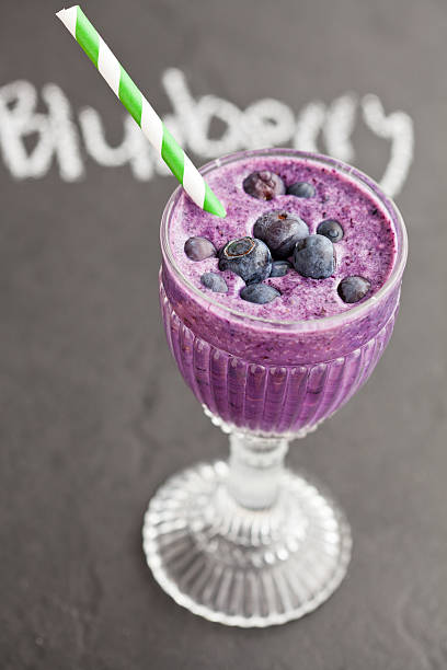 blaubeer-milch-smoothie - blueberry smoothie glass striped stock-fotos und bilder