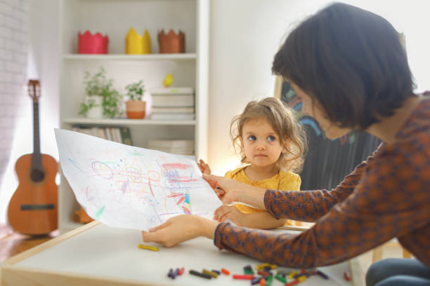 istock Mother and daughter sitting on the table and drawing. 1756757913
