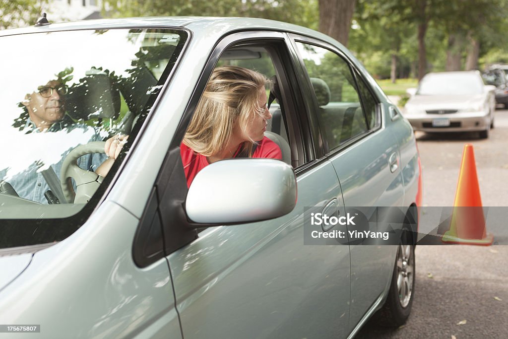 Teen motorista aprendizagem paralelo estacionamento com instrutor e Cone - Foto de stock de Aprender a dirigir royalty-free