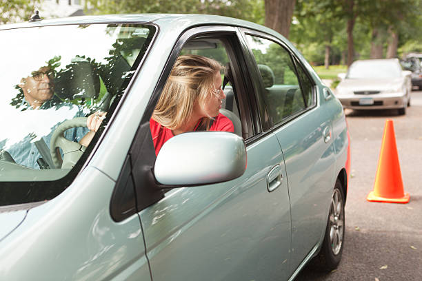 teen motorista aprendizagem paralelo estacionamento com instrutor e cone - aprender a conduzir - fotografias e filmes do acervo