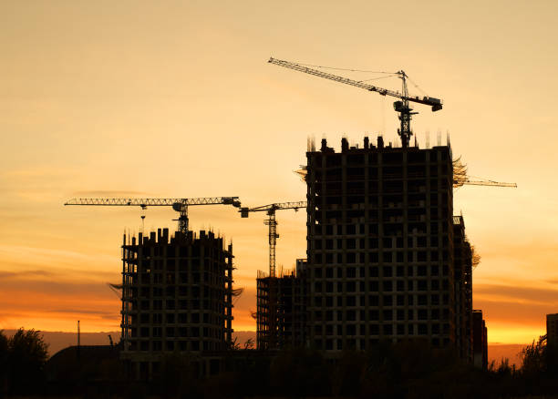 istock Tower cranes silhouette against yellow sunset 1756760534