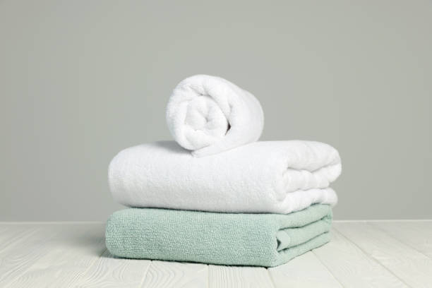 istock Soft towels on white wooden table against light grey background 1756766972