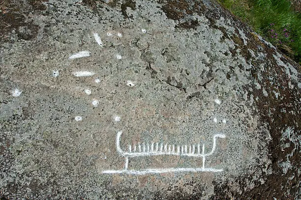 The Rock-carving from Viking Age, named Dalby 172:1, is a 90 cm long ship with high stems and with 18 marks for the crew. There are also around forty elf-stones in the rock, Uppland, Sweden
