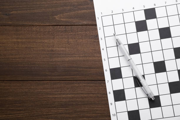 istock Blank crossword and pen on wooden table, top view. Space for text 1756768608