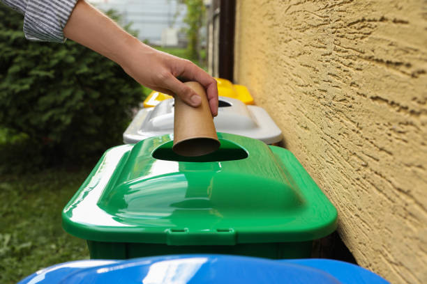 istock Woman throwing paper coffee cup into recycling bin outdoors, closeup 1756784631