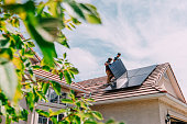 Go Green: Young Homeowners installing Solar Panels on a Suburban Western USA Home