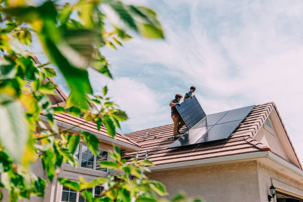 Go Green: Young Homeowners installing Solar Panels on a Suburban Western USA Home Low Angle view of Two Caucasian Male Homeowners or DIY-ers installing Solar Panels to Brackets on a Suburban Home with Clay Tiles in the Summer installing stock pictures, royalty-free photos & images