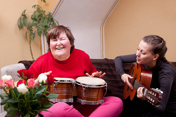 Two women with musical instruments having fun Two women make a music therapy and having fun disabled adult stock pictures, royalty-free photos & images