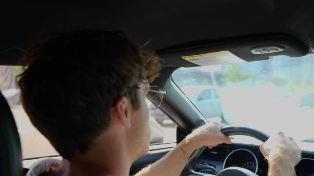 istock Young man feeling comfortable while sitting on driver seat in his car. Back view. Transport and lifestyle concept. Slow motion 1756811074