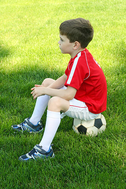 istock boy sitting on a soccer ball 175682471