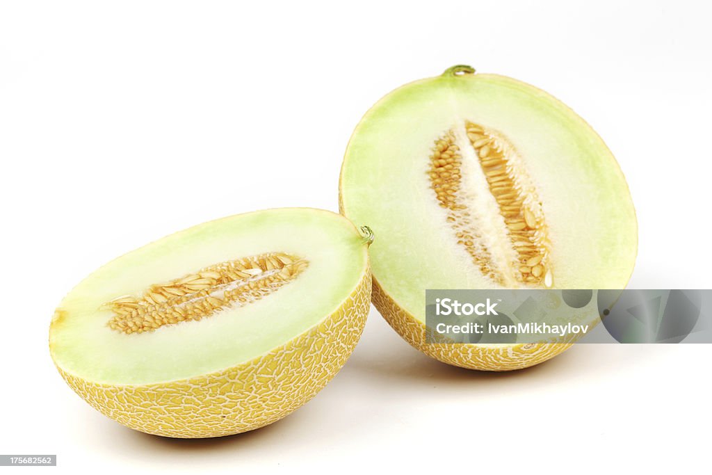 A sliced greenish-yellow galia melon showing the seeds  galia slice melone isolated on white Cut Out Stock Photo