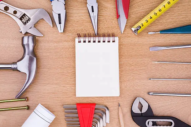 construction:Work Tools and blank notebook on wood