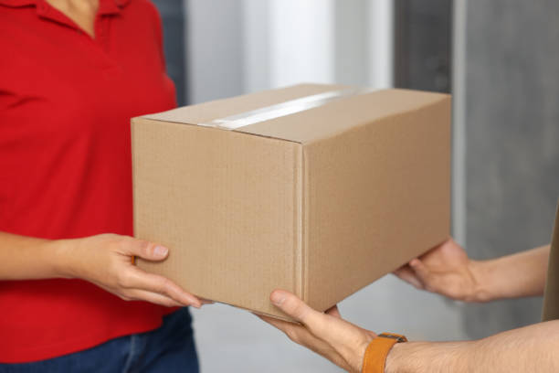 istock Courier giving parcel to customer in hallway, closeup 1756834928