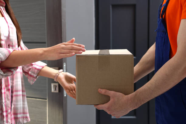 istock Woman receiving parcel from courier at home, closeup 1756835988