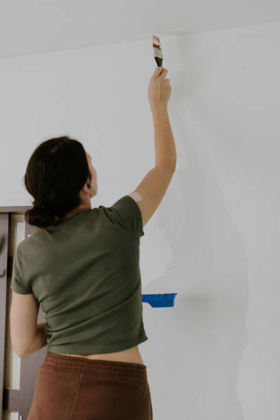 istock A young girl paints the ceiling with a brush. 1756856067