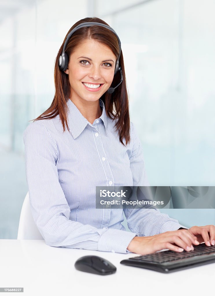 I'm a multi-tasker! A businesswoman wearing a headset and typing 20-24 Years Stock Photo