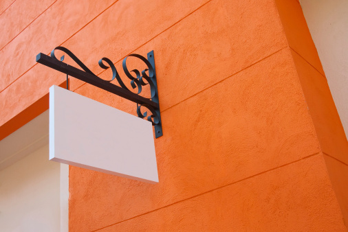 blank sign board on orange wall