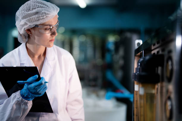 istock scientist worker checking the quality of Reverse osmosis machine system at the industrial factory. Female worker recording data at the control panel with measure pressure for recycle portable plant. 1756896731