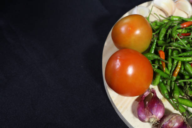 istock tomatoes, red onions and green chilies with a black background 1756907155