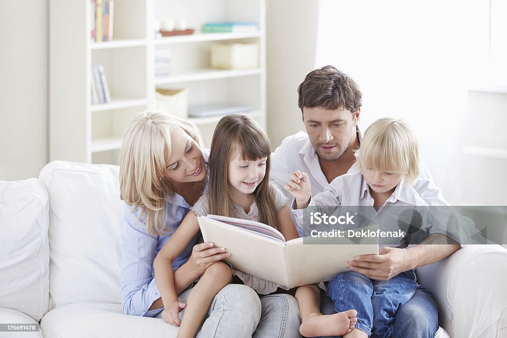 Leisure Young parents read the book to children at home Child Stock Photo