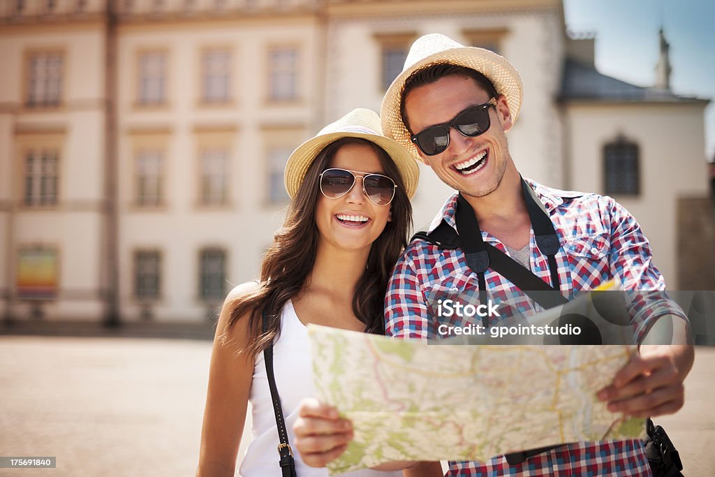 Happy tourists couple holding map Happy tourists couple holding map  Tourist Stock Photo