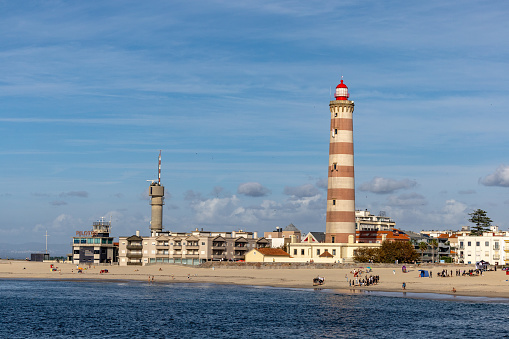 Aveiro, Portugal Sept 20, 2023 The Farol de Aveiro, or Aveiro lighthouse in  the Praia da Barra seaside  district and beachgoers.