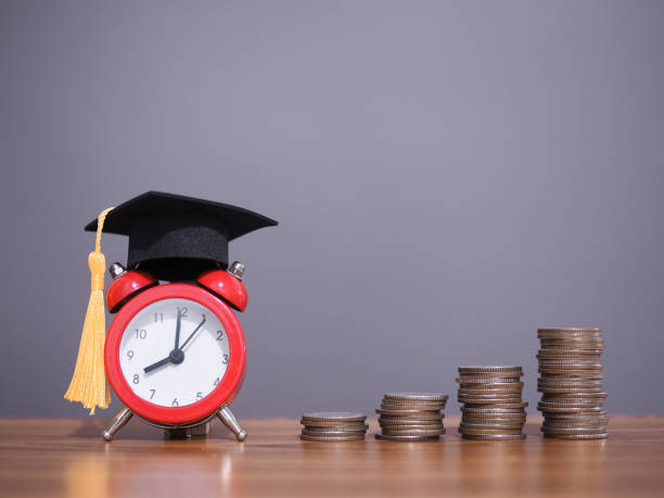 istock Study goals, Red alarm with graduation hat and stack of coins. The concept for Resolution, Goal, Action, Planning, and manage time to success graduate 1756947796