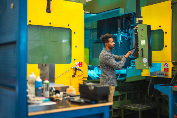 istock Black Mid Adult Male Worker Programming CNC Machine 1756949376