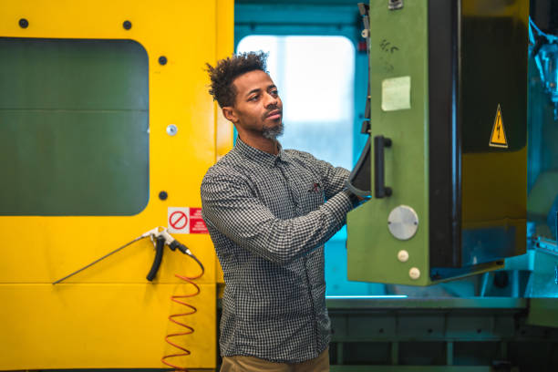 istock Mid Adult Black Male Pressing Controls On A CNC Machine 1756949380