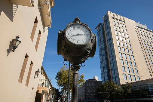 Daytime view of a historic clock and downtown skyline of San Jose, California, USA.