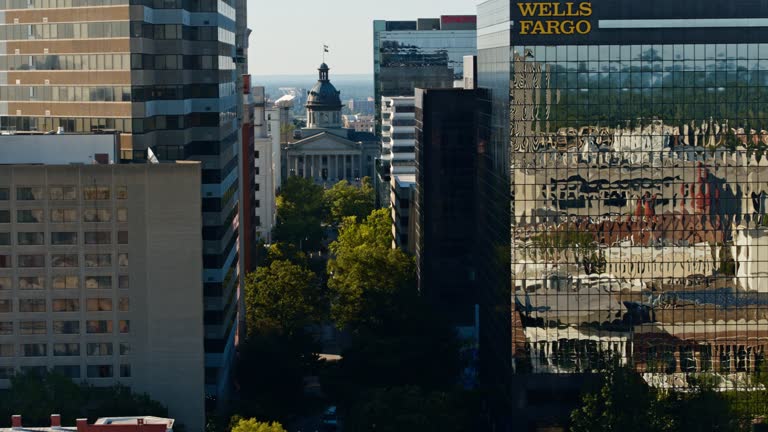 Columbia, SC central State House stands at the core of a tree-lined Main Street, flanked by skyscrapers. View from Downtown Columbia, SC. Aerial footage with panning camera motion