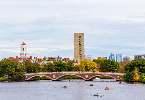 Cambridge, Massachusetts, USA - October 20, 2023: The Head of the Charles Regatta, also known as HOCR, is a rowing head race held on the penultimate complete weekend of October  each year on the Charles River, which separates Boston and Cambridge, Massachusetts. It is the largest 3-day regatta in the world, with 11,000 athletes rowing in over 1,900 boats in 61 events.  View toward the pedestrian John Weeks Bridge. Harvard University's Cambridge campus in the background.