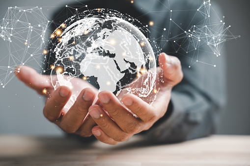 Digital Transformation of Business, A businessman holds a globe, illustrating seamless connection enabled by technology. Big data analytics and business intelligence drive evolution of global economy.