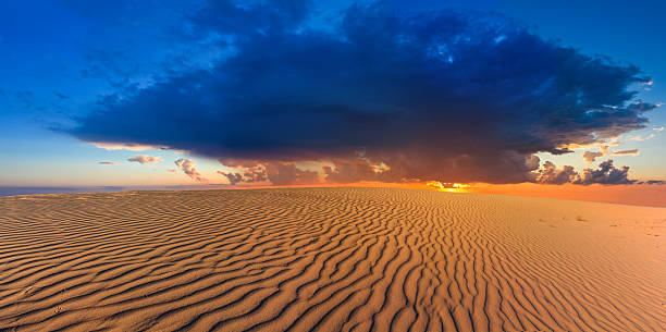 dramatischer sonnenuntergang inmitten einer wüste - friable stock-fotos und bilder
