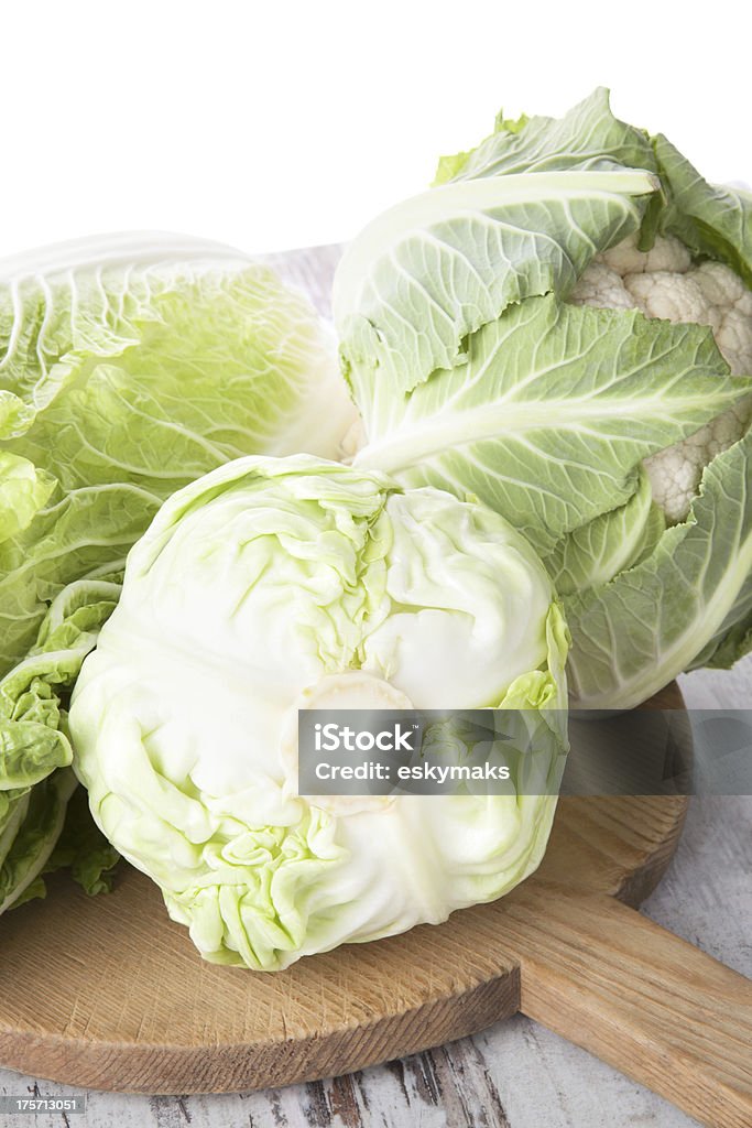 Cabbage and cauliflower still life, country style. Cabbage, chinese cabbage and cauliflower on white wooden cutting board on white textured wooden background. Healthy summer vegetable, country style. Bok Choy Stock Photo