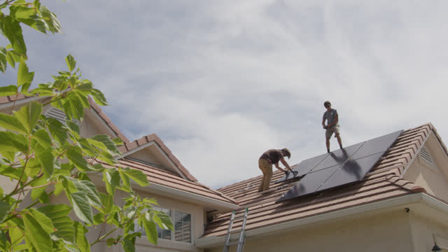 DIY: Young Homeowners Working Together installing Solar Panels on a Suburban Home in the Southwest USA