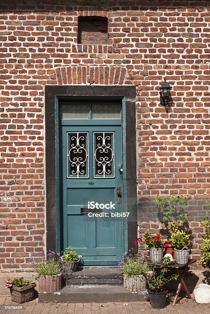 door in 19th century house house door decorated with flowers on the steps - house built in 19th century - brick walls typical for Ruhr region Brick Wall Stock Photo