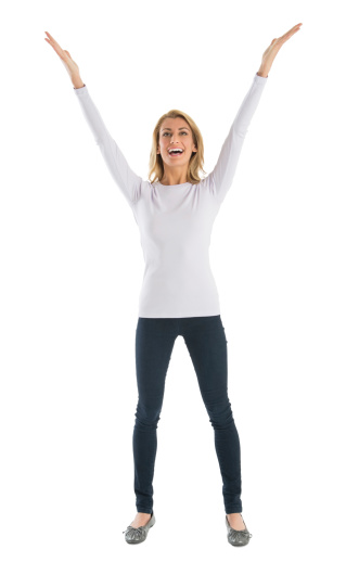 Cheerful young woman with arms raised looking away while standing against white background