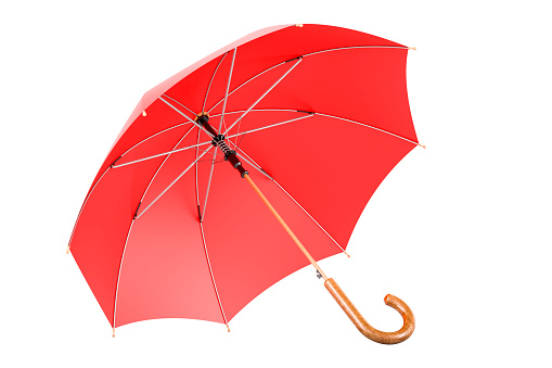 An open red umbrella on a grass lawn surface