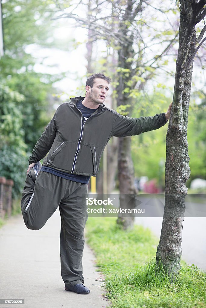 Stretching Man stretching after running in the streets. 25-29 Years Stock Photo