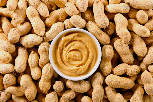 Peanut butter in bowl with peanut background